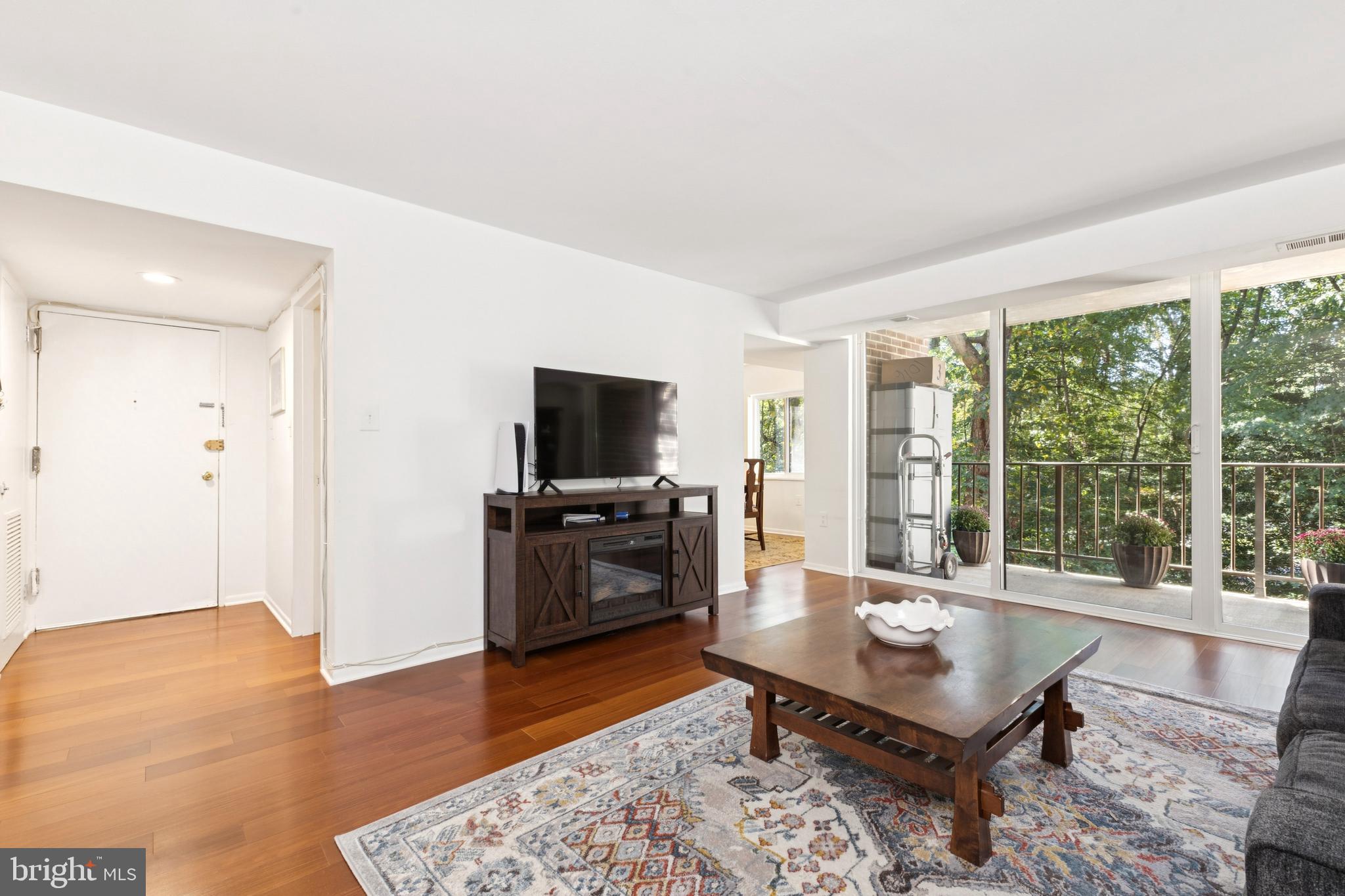 1413 Northgate Square, Unit 13/12B Reston, VA 20190 - Photo 5 of 25 a living room with furniture a flat screen tv and floor to ceiling window