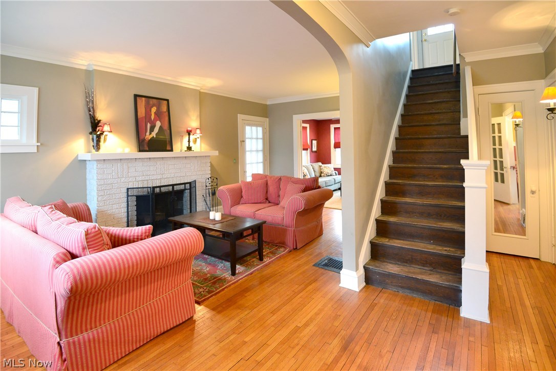 15629 Munn Road Cleveland, OH 44111 - Photo 2 of 24 Freshly painted w/ Hrdwd flrs thru out, the open Foyer leads into an elegant Living area w/WBFP, decorative Light Fixtures, Crown Molding & tall windows facing the front..A Mirrored Coat closet is to the right of the stairs case as is the Formal Din rm