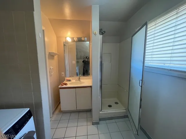 a bathroom with a granite countertop sink mirror and shower