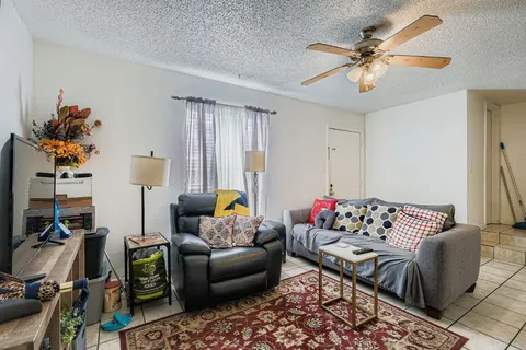a living room with furniture chess board and a flat screen tv