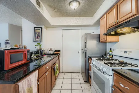 a kitchen with stainless steel appliances granite countertop a stove a refrigerator and a refrigerator