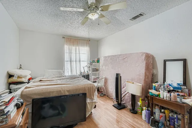 a bedroom that has a bed and a flat tv screen on the dresser