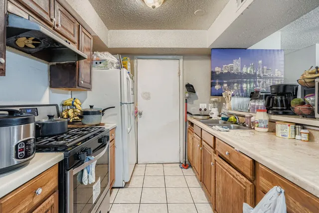 a kitchen with stainless steel appliances a sink stove and refrigerator