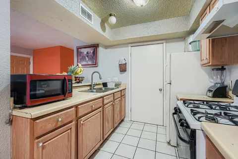 a kitchen with stainless steel appliances a stove a microwave and a sink