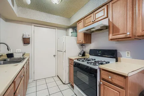 a kitchen with stainless steel appliances granite countertop a stove a refrigerator and a sink