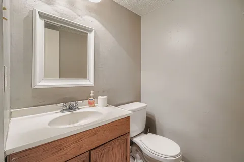a bathroom with a sink a toilet and mirror