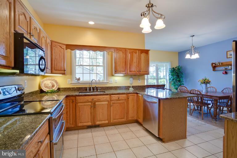 13415 Fork Road Baldwin, MD 21013 - Photo 27 of 29 a kitchen with stainless steel appliances granite countertop a stove a sink and a microwave