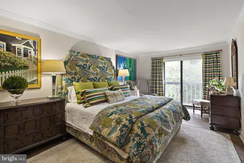 a bedroom with a bed and large windows