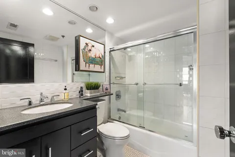 a bathroom with a double vanity sink toilet mirror and shower