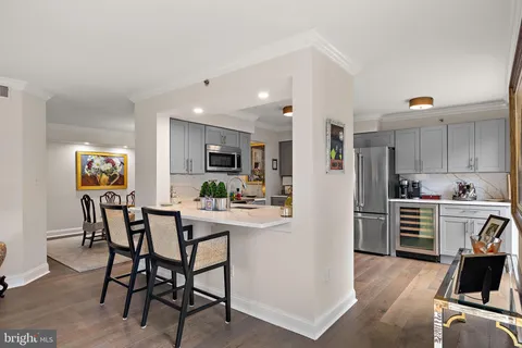 a kitchen with stainless steel appliances kitchen island granite countertop a table and chairs in it