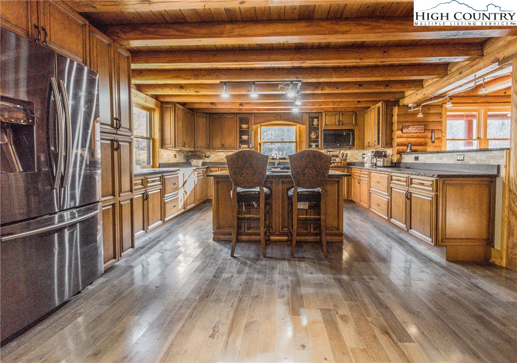 3654 Andy Hicks Road Banner Elk, NC 28604 - Photo 31 of 40 a kitchen with stainless steel appliances granite countertop a refrigerator a stove and a dining table with wooden floors