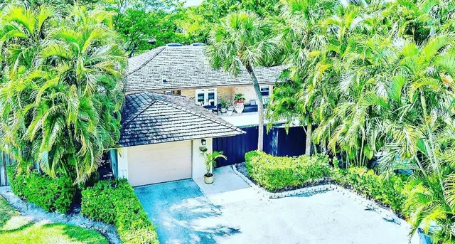 an aerial view of a house with yard and greenery space