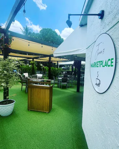 a dining room with furniture a potted plant and a large window