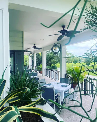 a view of a white house in a big yard with large trees