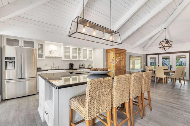 a kitchen with stainless steel appliances granite countertop a table chairs and a chandelier