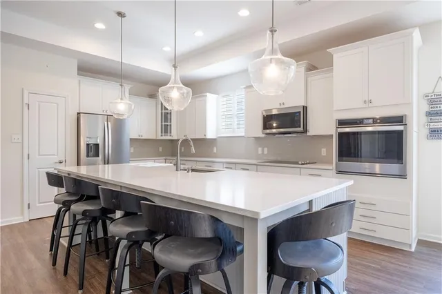 a kitchen with kitchen island a dining table chairs sink and microwave