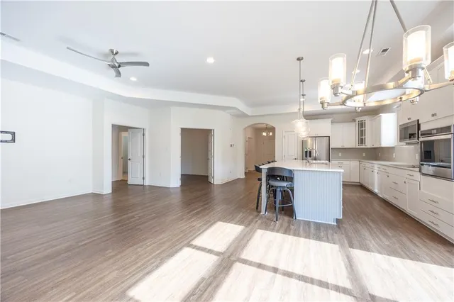 a view of a dining room and livingroom with furniture wooden floor a chandelier