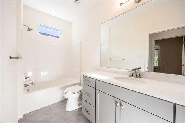 a bathroom with a sink a toilet and a large mirror