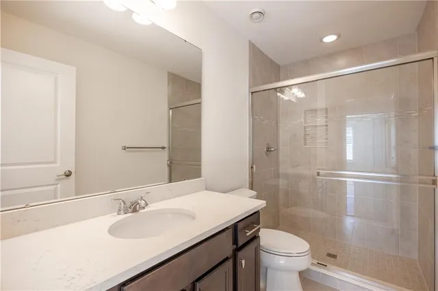 a bathroom with a granite countertop sink toilet and shower