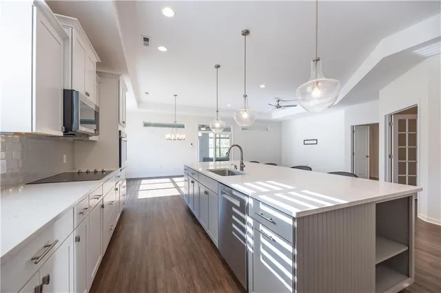 a kitchen with kitchen island a sink and a stove top oven with wooden floor