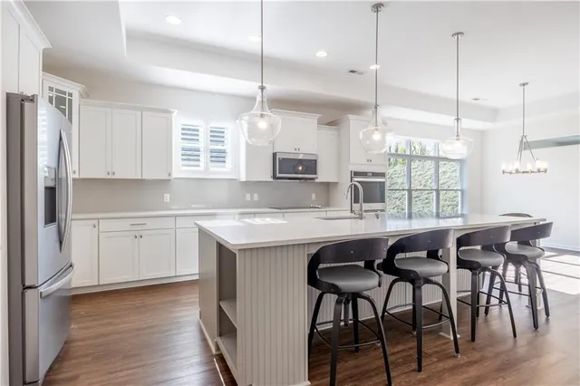 a kitchen with granite countertop a table chairs stove and wooden floor
