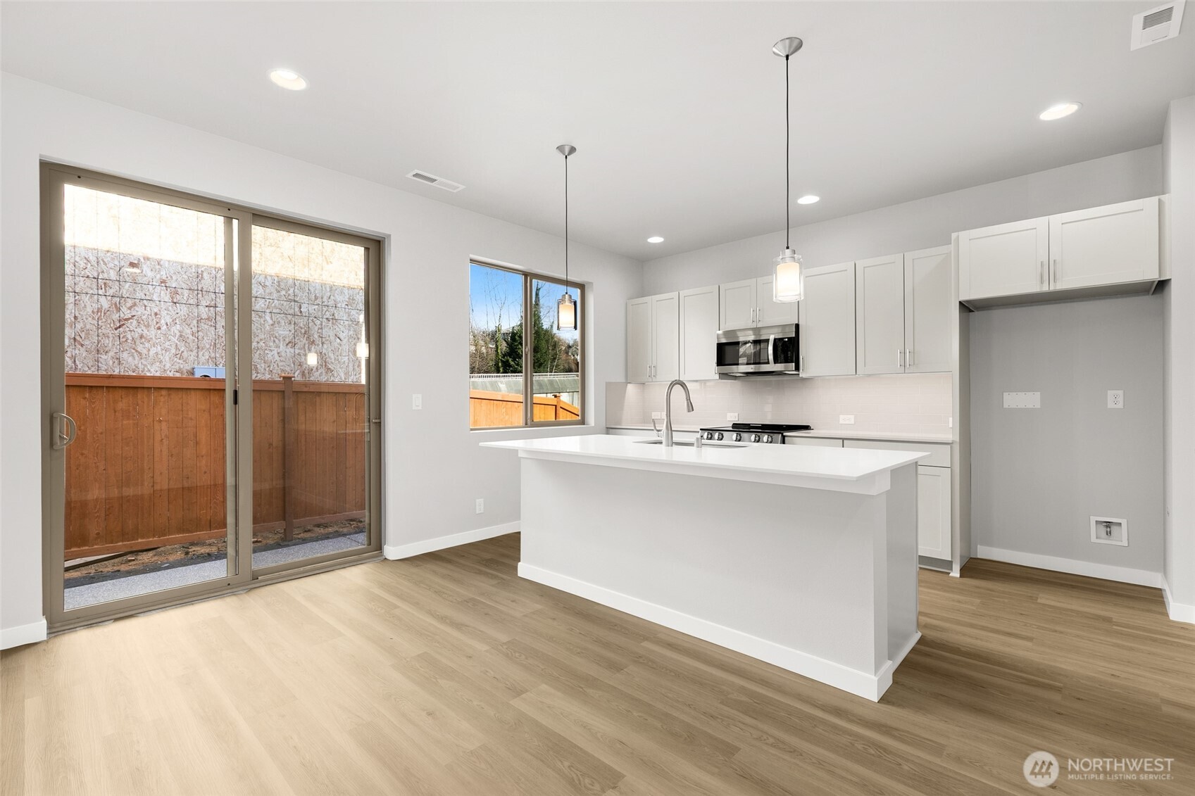12510 Southeast 256th Place, Unit 7 Kent, WA 98030 - Photo 12 of 39 a view of kitchen with stainless steel appliances granite countertop a stove top oven a refrigerator a sink and a dining table with wooden floor