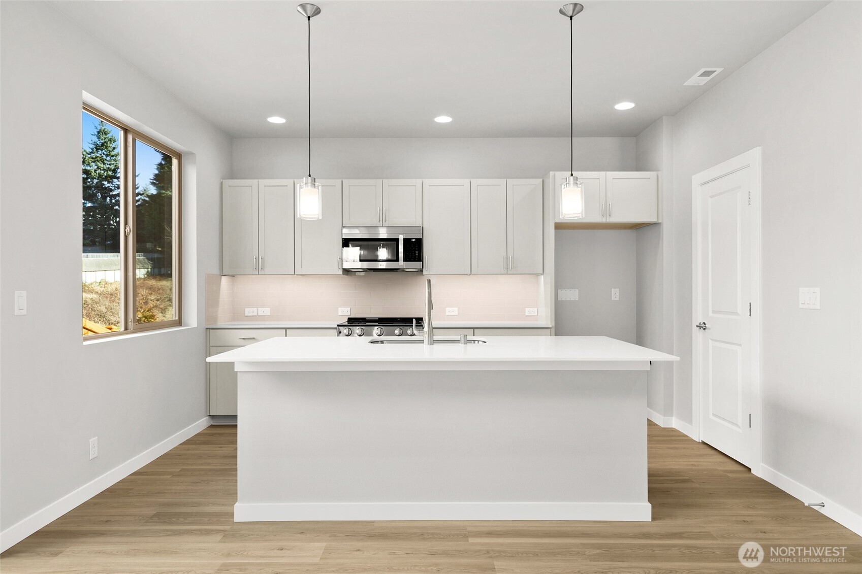 12510 Southeast 256th Place, Unit 7 Kent, WA 98030 - Photo 13 of 39 a kitchen with kitchen island a stove a sink a center island and wooden floor