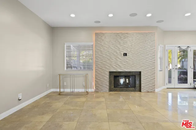 a view of an empty room with a fireplace and a window