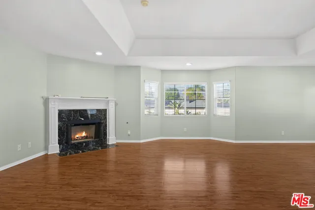 a view of an empty room with window and fire place