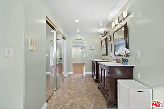 a spacious bathroom with a bathtub a sink and a mirror