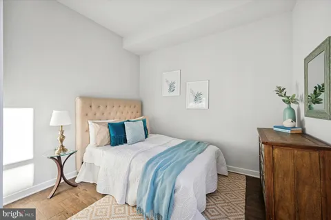 a bedroom with a bed and wooden floor