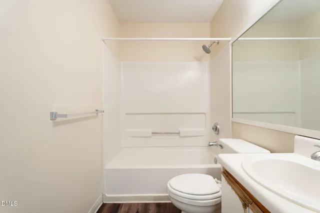 a kitchen with stainless steel appliances granite countertop a refrigerator a stove and white cabinets with wooden floor