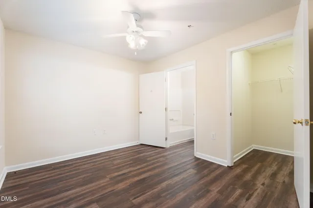 a view of a room with wooden floor and a ceiling fan