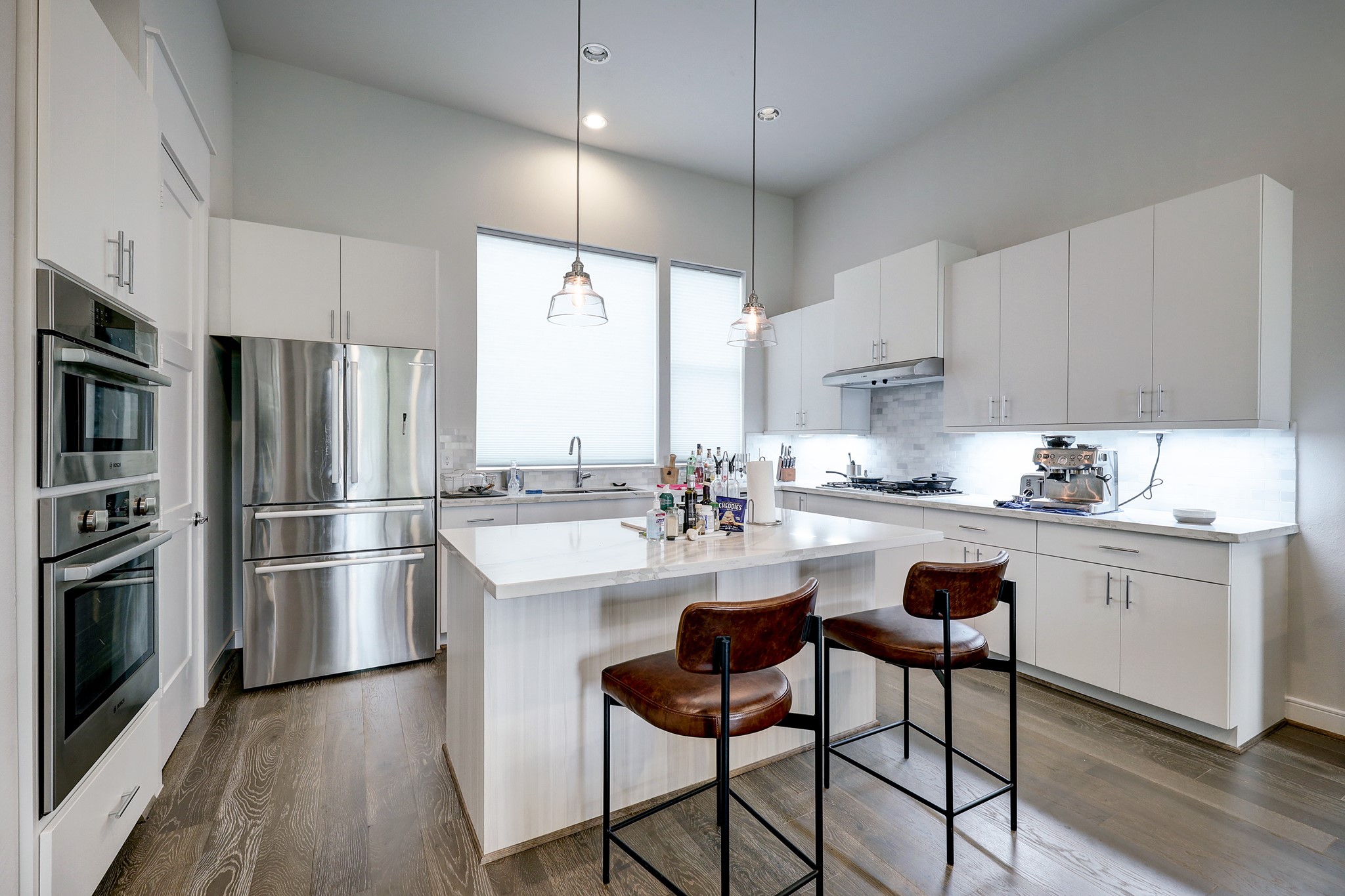 1203 Hickory Street, Unit D Houston, TX 77007 - Photo 12 of 23 a kitchen with stainless steel appliances a refrigerator a stove a sink and white cabinets with wooden floor