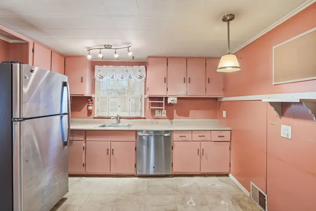 a kitchen with a sink a refrigerator and window