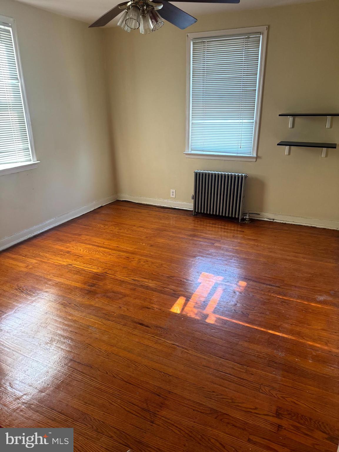 1629 Murdoch Road, Unit B2 Philadelphia, PA 19150 - Photo 2 of 7 an empty room with wooden floor and windows