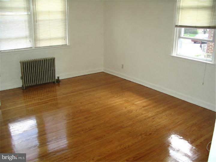 1629 Murdoch Road, Unit B2 Philadelphia, PA 19150 - Photo 9 of 9 a view of an empty room with wooden floor and a window