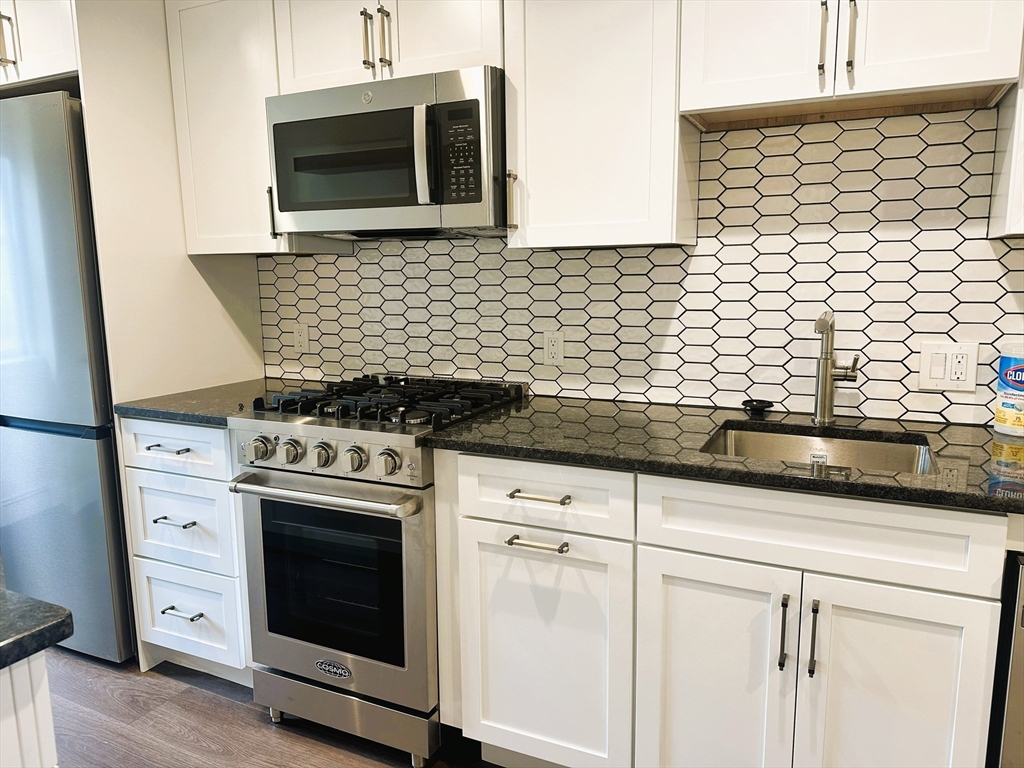 15 Clark Street, Unit 3 Boston, MA 02113 - Photo 1 of 8 a kitchen with granite countertop cabinets stainless steel appliances and wooden floor