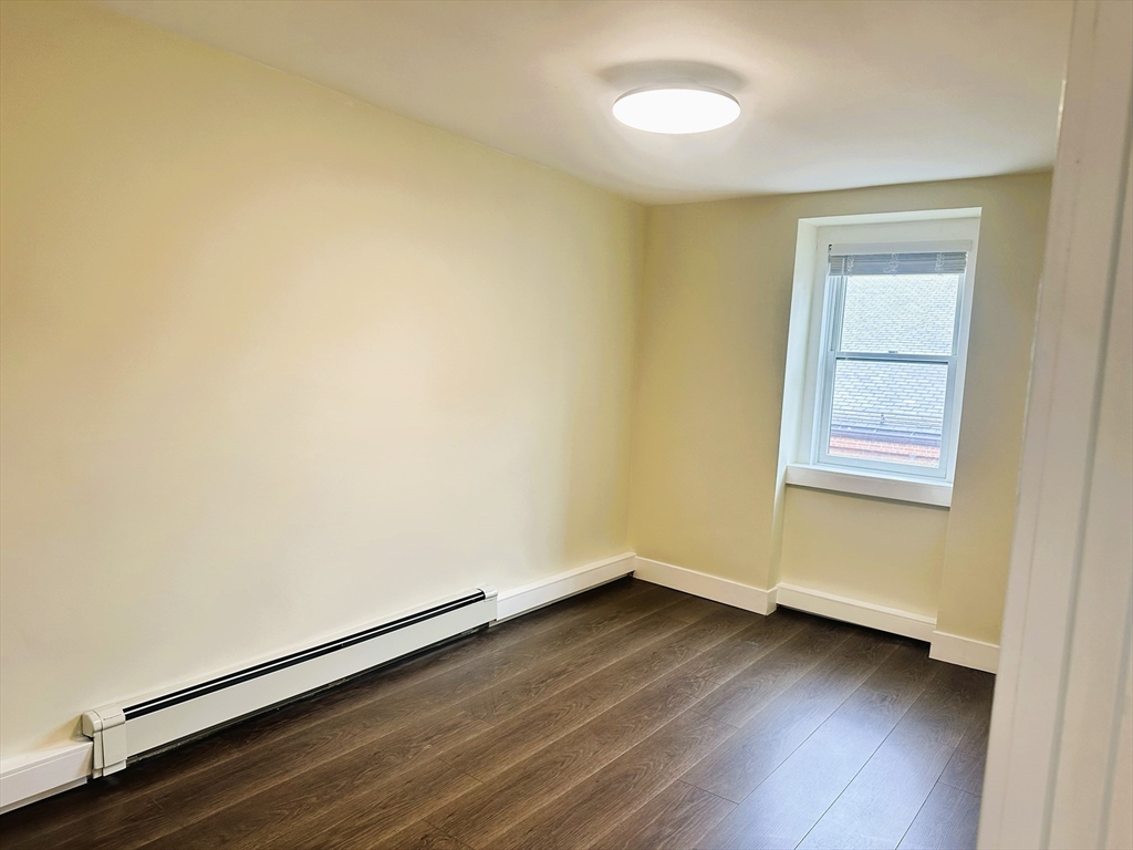 15 Clark Street, Unit 3 Boston, MA 02113 - Photo 5 of 8 an empty room with wooden floor and windows