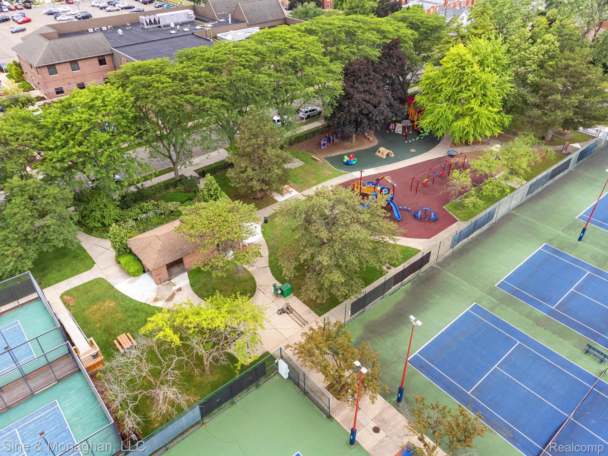 679 Neff Road Grosse Pointe, MI 48230 - Photo 51 of 78 Park setting featuring multiple tennis courts, a playground with various equipment, mature trees, and a dedicated park building