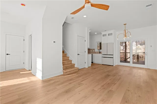 an open kitchen with wooden floor and stainless steel appliances