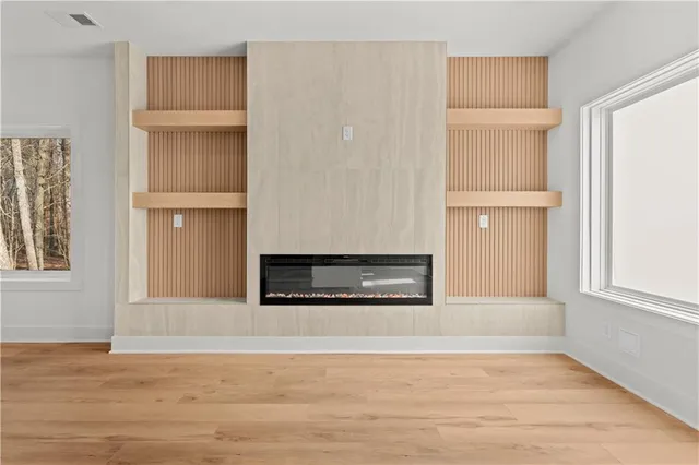 a view of an empty room with a window and a kitchen