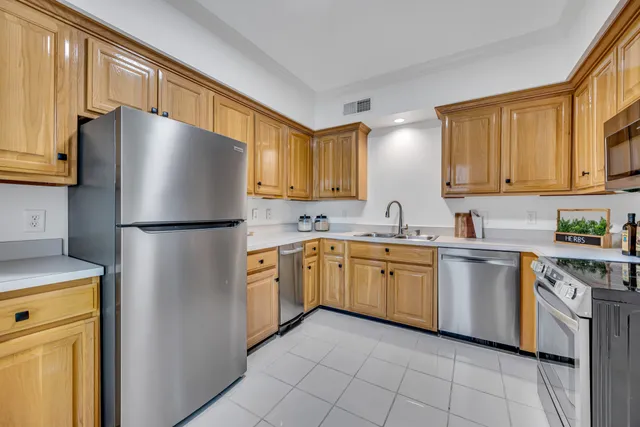 a kitchen with stainless steel appliances granite countertop a refrigerator a stove a sink dishwasher and a refrigerator