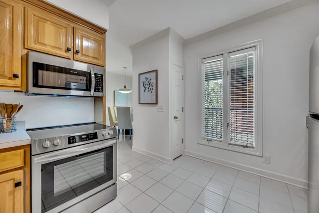 a kitchen with granite countertop cabinets stainless steel appliances and a window