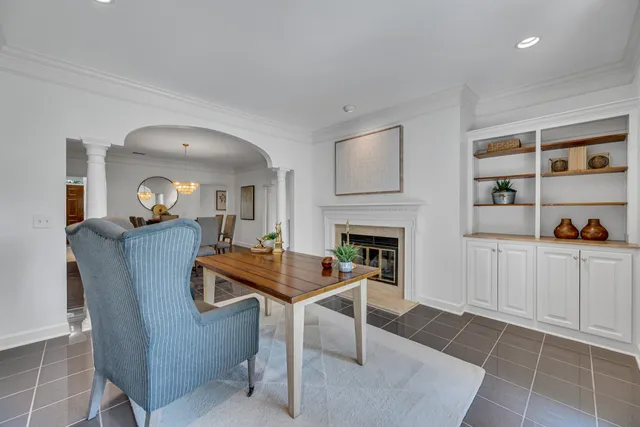 a living room with furniture a fireplace and a refrigerator
