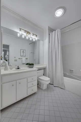 a spacious bathroom with a double vanity sink toilet and a tub