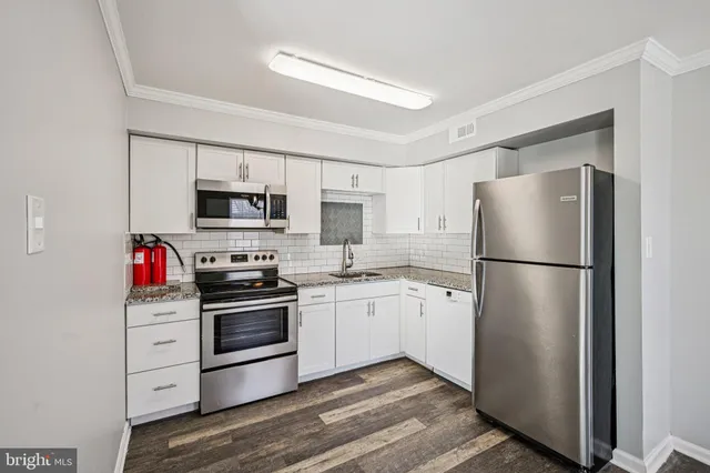 a kitchen with stainless steel appliances a refrigerator stove and microwave