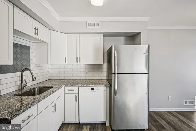 a kitchen with a refrigerator sink and cabinets