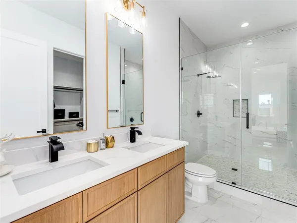 a bathroom with a sink a toilet and shower