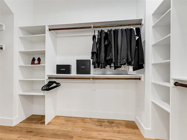 a view of walk in closet with clothes and shoes